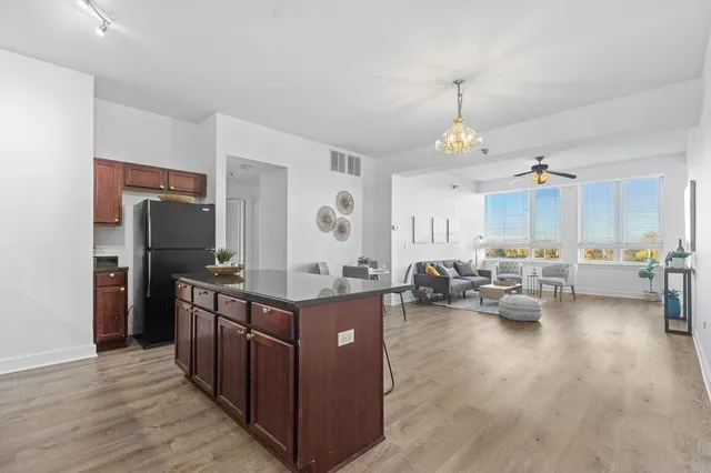 a kitchen with stainless steel appliances granite countertop a stove and a wooden floors