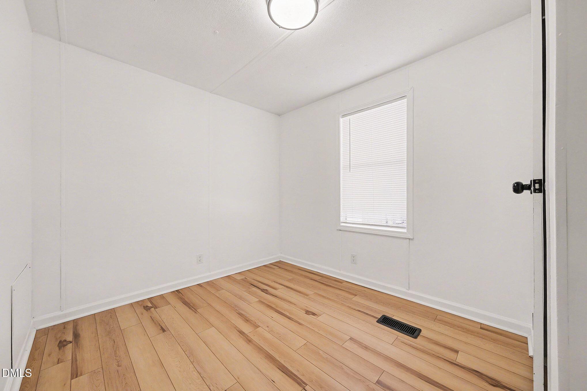 7223 Apple Mill Road Efland, NC 27243 - Photo 24 of 31 a view of a room with wooden floor and white walls