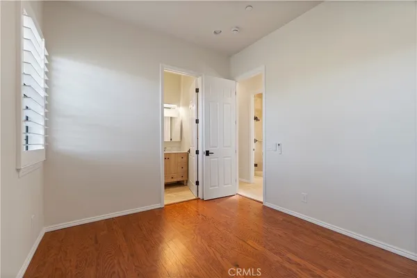 a view of hallway with closet and wooden floor
