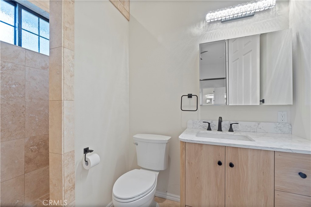 37420 Leta Drive Calimesa, CA 92320 - Photo 14 of 24 a bathroom with a toilet sink vanity and mirror