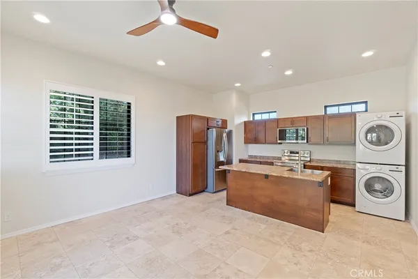 a view of kitchen with stainless steel appliances granite countertop a stove and a refrigerator