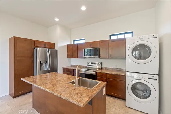 a kitchen with stainless steel appliances granite countertop a sink a stove a refrigerator and cabinets