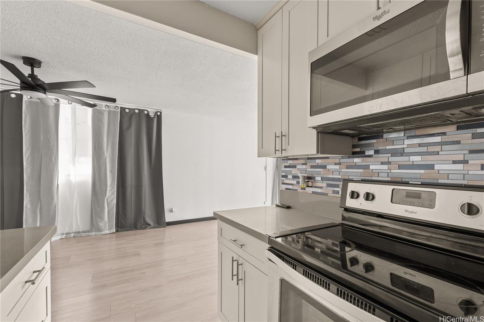 1069 Spencer Street, Unit 101 Honolulu, HI 96822 - Photo 4 of 19 a kitchen with a stove and a microwave