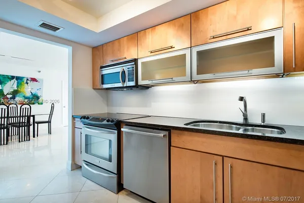 a kitchen with stainless steel appliances granite countertop a stove a microwave and a sink