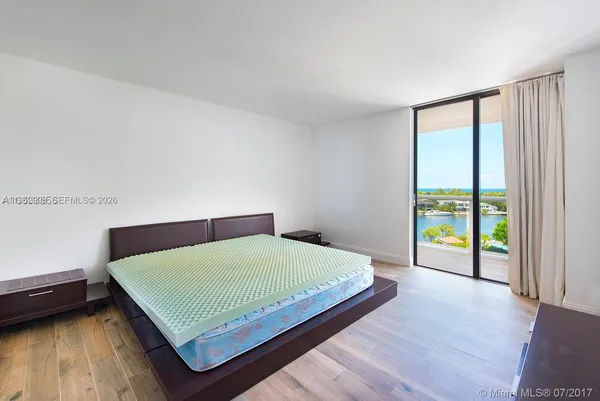 a bedroom with a bed and a large window