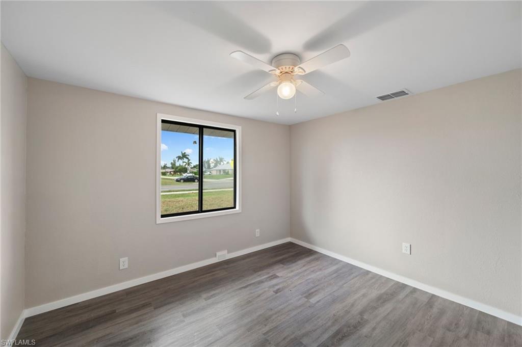 17568 Lee Road Fort Myers, FL 33967 - Photo 15 of 22 a view of an empty room with wooden floor and a window