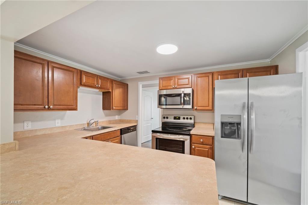 17568 Lee Road Fort Myers, FL 33967 - Photo 3 of 22 a kitchen with stainless steel appliances granite countertop a refrigerator and a stove top oven