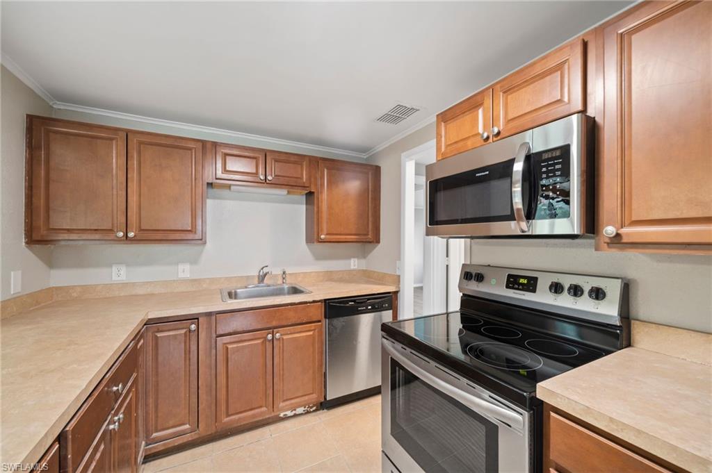 17568 Lee Road Fort Myers, FL 33967 - Photo 4 of 22 a kitchen with a sink stove top oven and cabinets