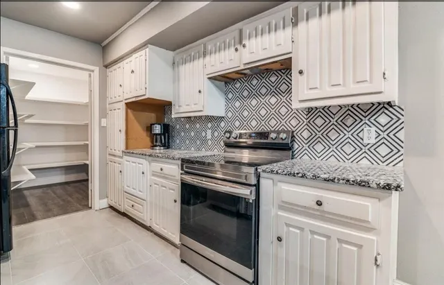 a bathroom with a granite countertop double vanity sink and a large mirror