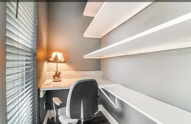 a room with a table chairs a lamp and entryway