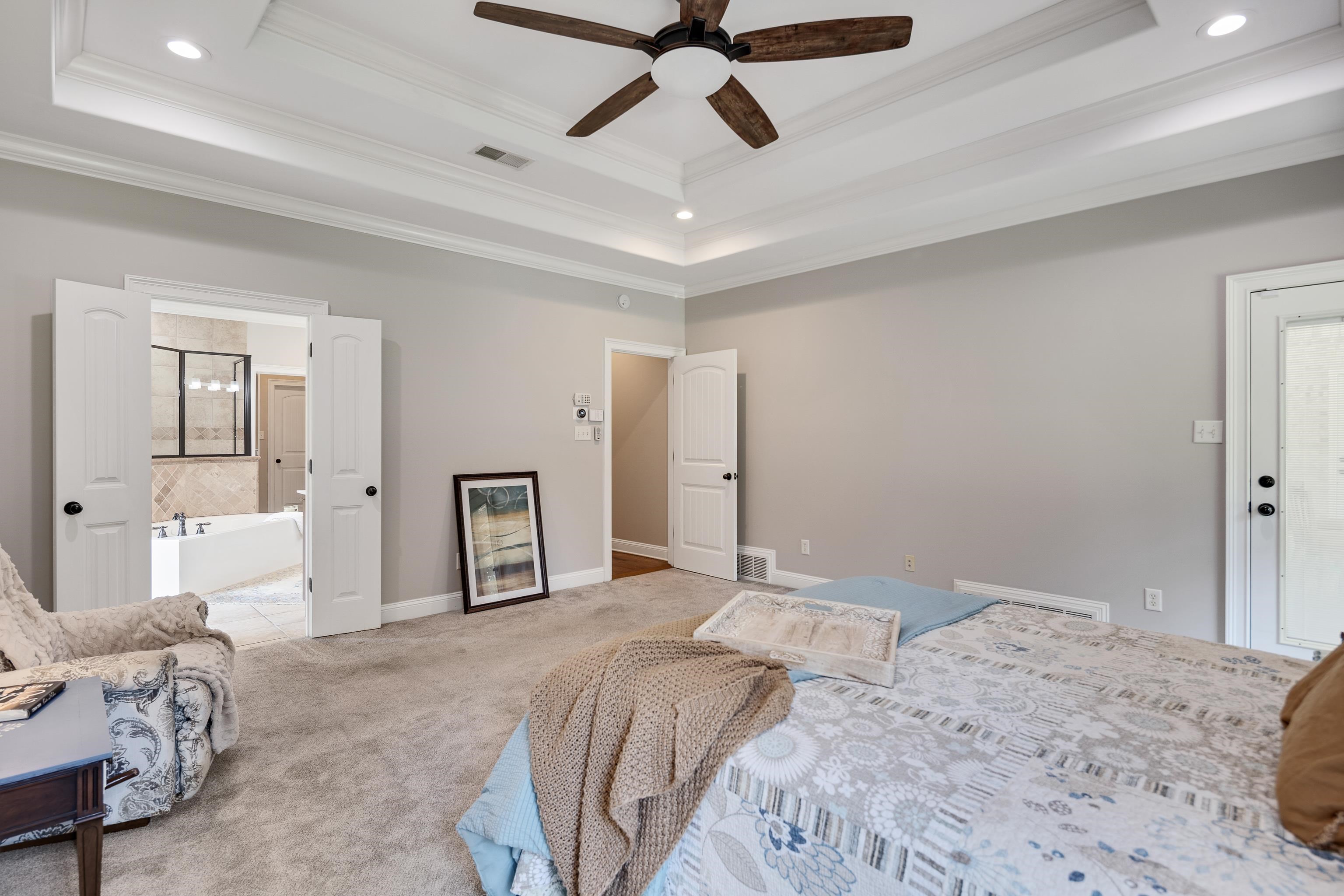 9028 Osborntown Road Arlington, TN 38002 - Photo 26 of 40 a bedroom with a large bed and a chandelier