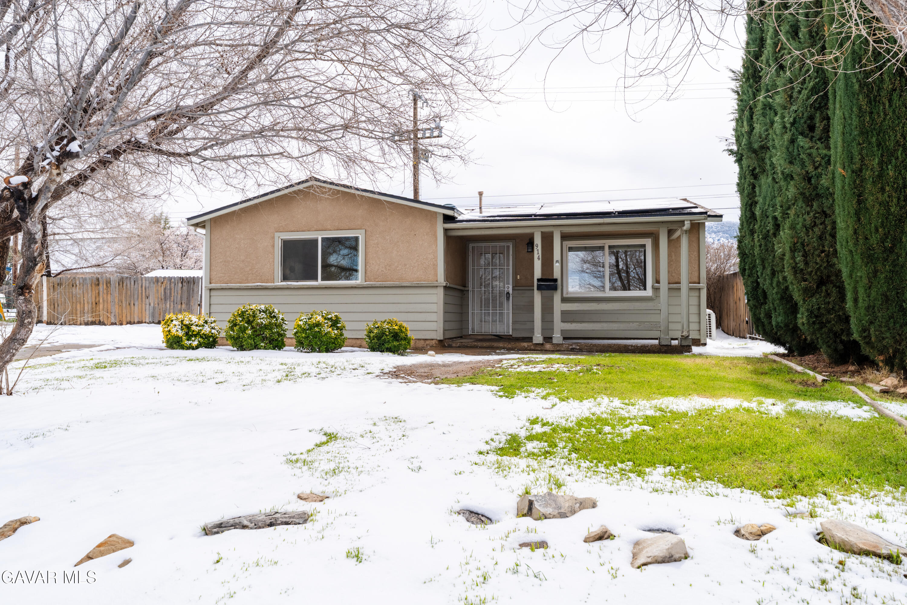 a front view of a house with a yard covered with trees