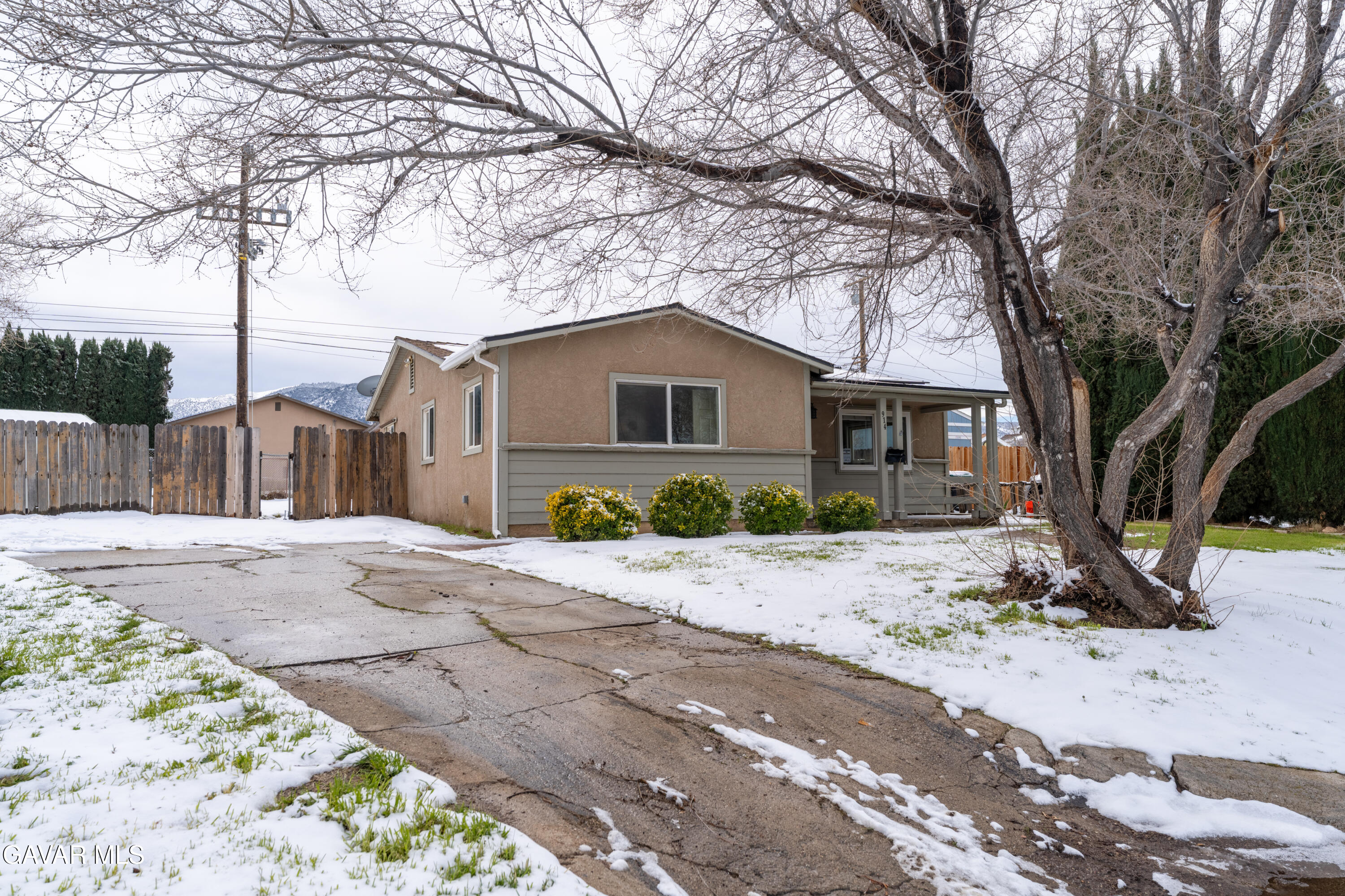 914 Acacia Court Tehachapi, CA 93561 - Photo 4 of 18 a front view of a house with a dirt yard and a large tree