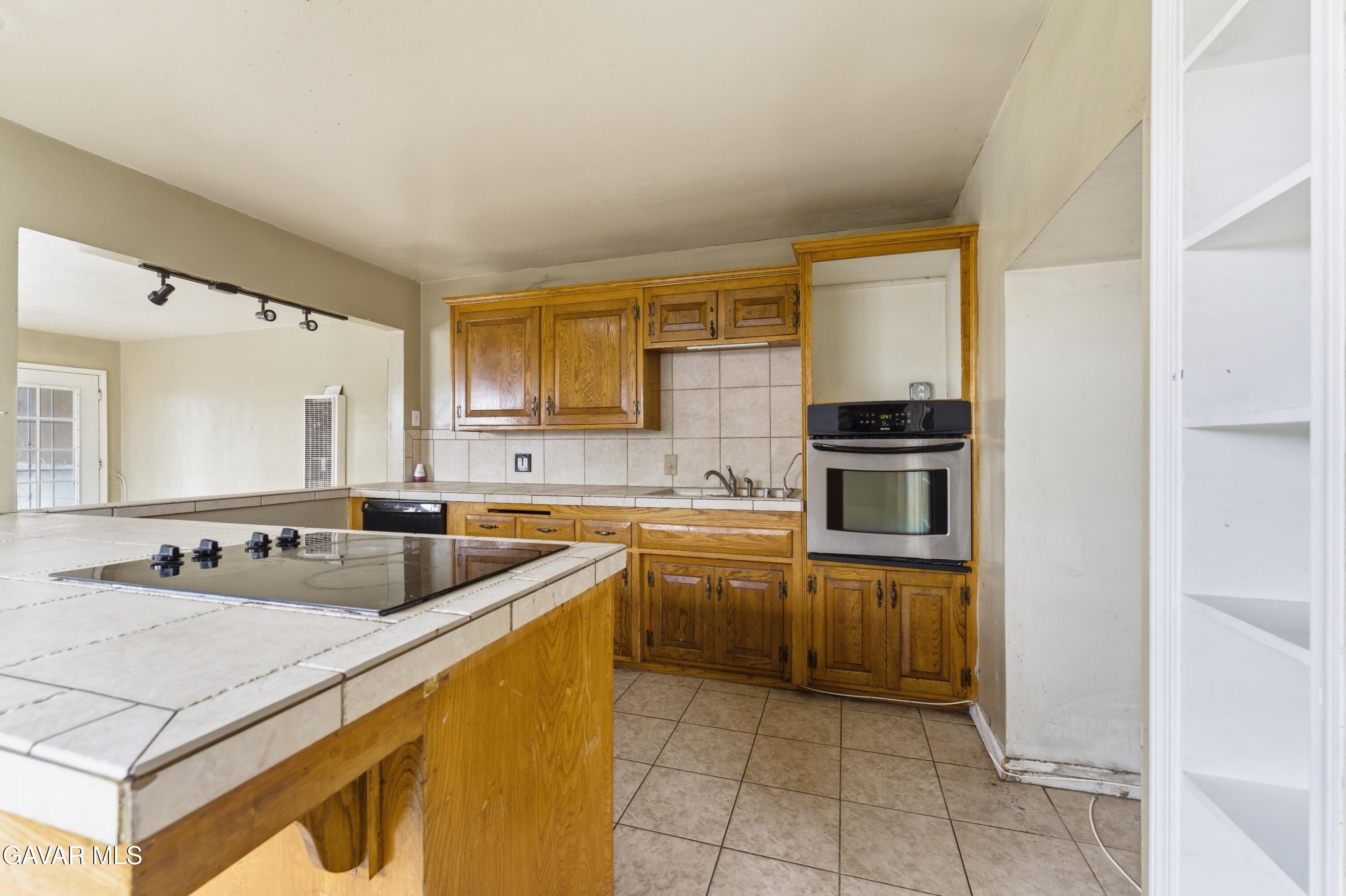914 Acacia Court Tehachapi, CA 93561 - Photo 6 of 18 a kitchen with a sink stove and cabinets