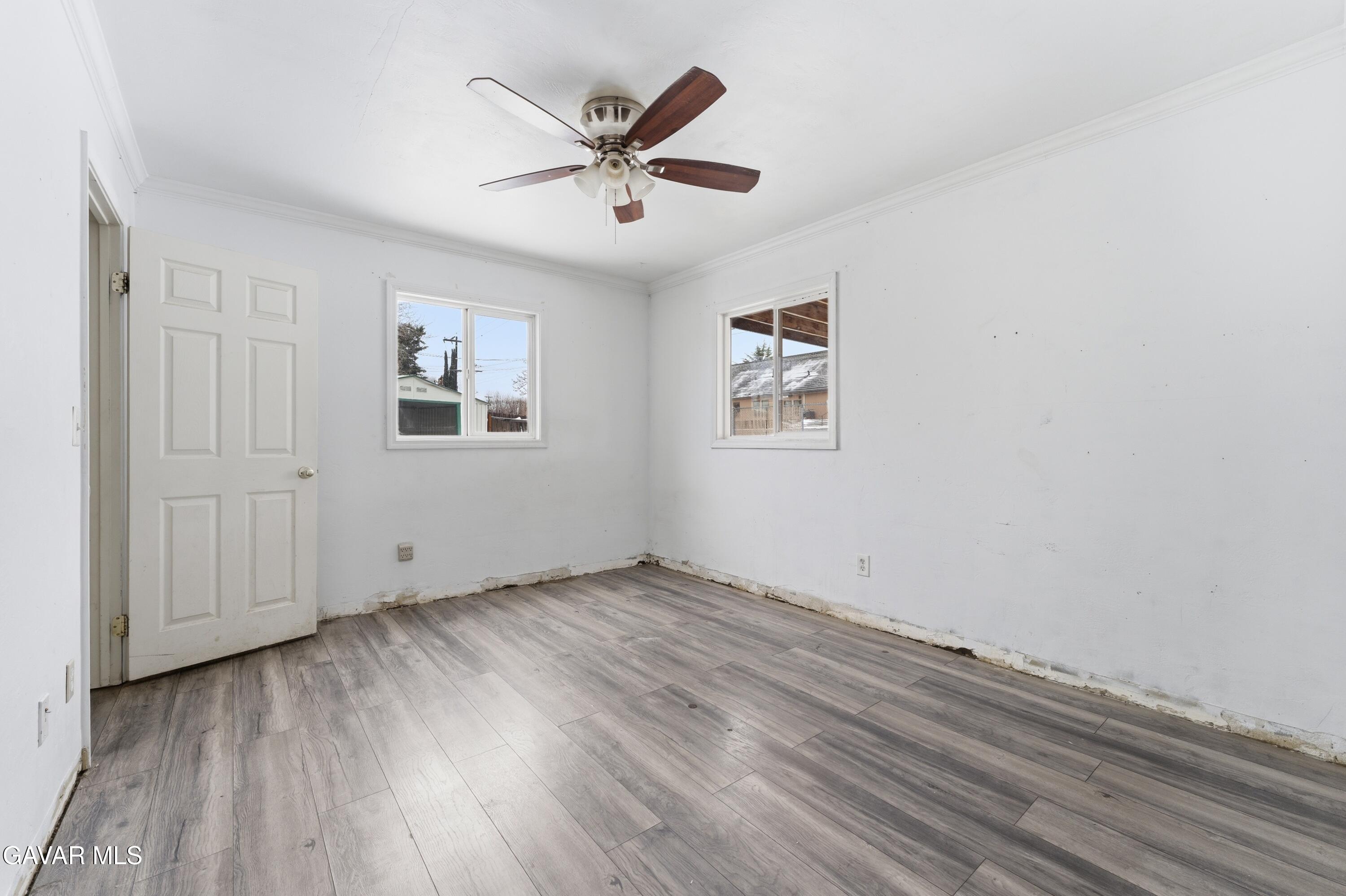 914 Acacia Court Tehachapi, CA 93561 - Photo 10 of 18 an empty room with wooden floor and windows