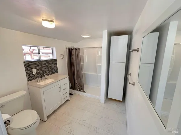 a bathroom with a granite countertop sink toilet and shower