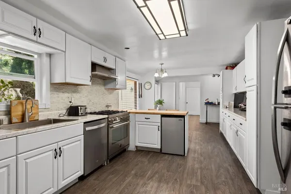 a kitchen with white cabinets and white appliances