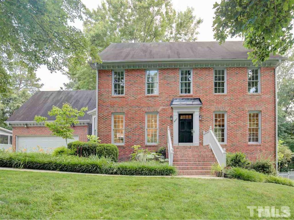 a front view of a house with a yard and trees