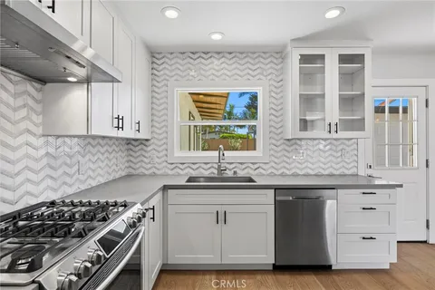 a kitchen with stainless steel appliances a stove and a sink