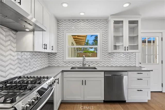 a kitchen with stainless steel appliances a stove and a sink