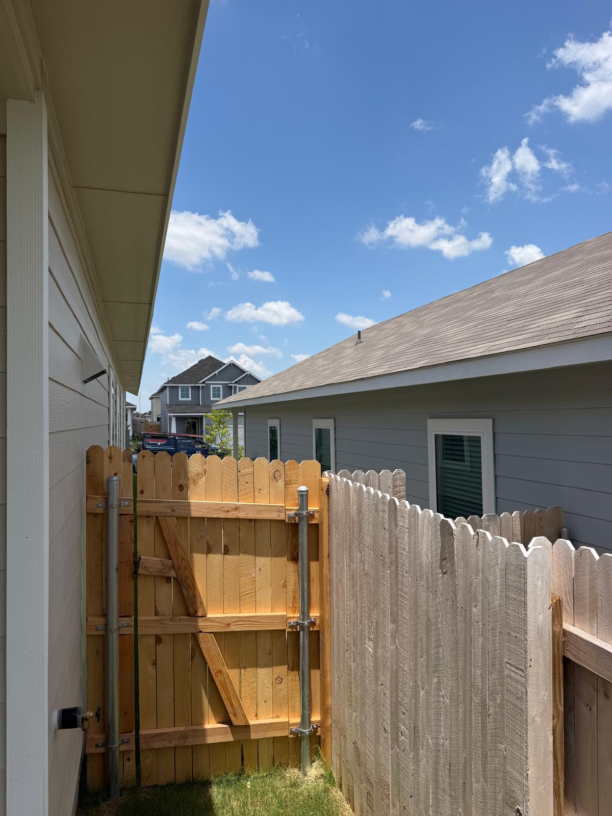 2701 Towy Road Manor, TX 78653 - Photo 29 of 35 Secure backyard access with this robust wooden fence and gate, framing a glimpse of the neighborhood.