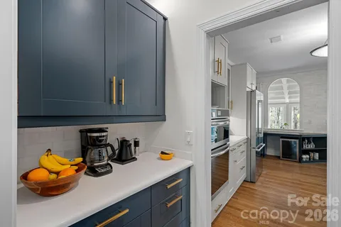 a kitchen with stainless steel appliances granite countertop a refrigerator a stove and a sink with wooden floor