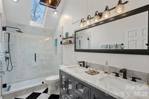 a bathroom with a sink a toilet and shower