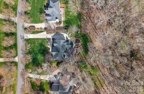 a aerial view of a house with a yard and large trees