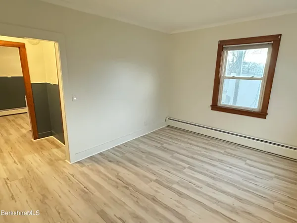 a view of a room with wooden floor and a window