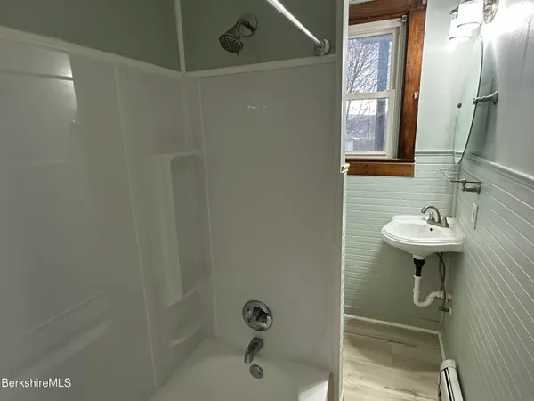 a bathroom with a sink a mirror and shower