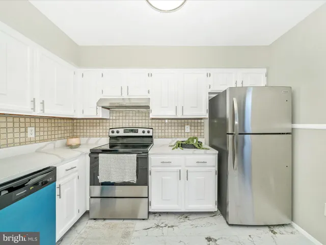 a kitchen with sink refrigerator and cabinets