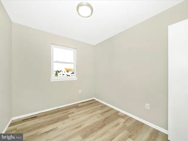 a view of a room with wooden floor and window
