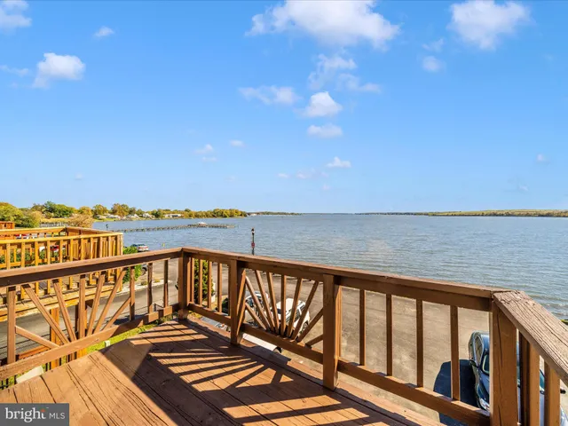 a view of a balcony with wooden floor & fence