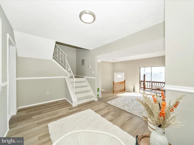 a view of a bedroom with wooden floor and white walls