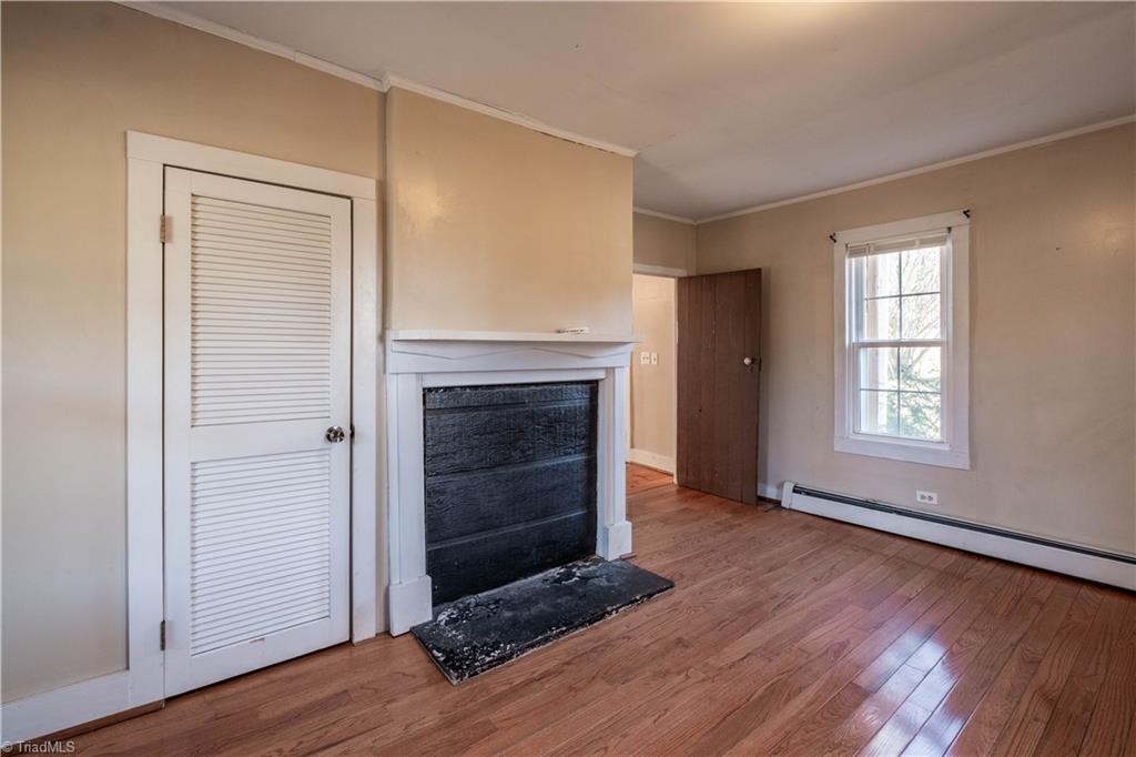 663 Ruritan Road Roaring River, NC 28669 - Photo 21 of 43 Primary bedroom located on main level with hardwood floors and non-working fireplace.