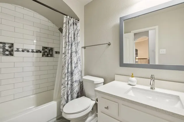 a spacious bedroom with a bed and a chandelier