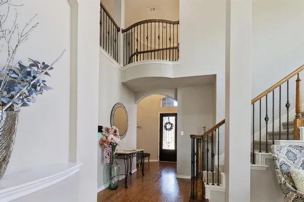 a view of staircase with lots of frames on wall clock and a potted plant