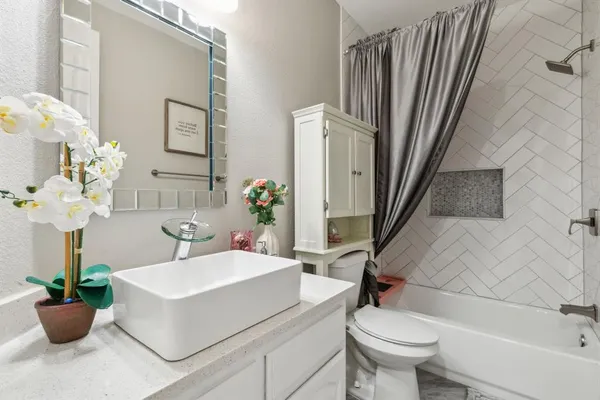 a bathroom with a sink a toilet and a mirror