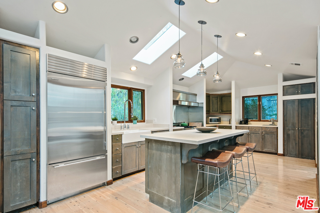 566 Stassi Lane Santa Monica, CA 90402 - Photo 13 of 26 a kitchen with a stove a refrigerator and a dining table