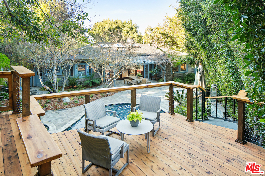 566 Stassi Lane Santa Monica, CA 90402 - Photo 25 of 26 a view of a balcony with table and chairs potted plants with wooden floor and fence