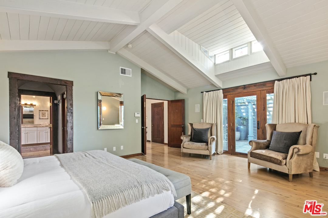 566 Stassi Lane Santa Monica, CA 90402 - Photo 9 of 26 a bedroom with a bed and large windows