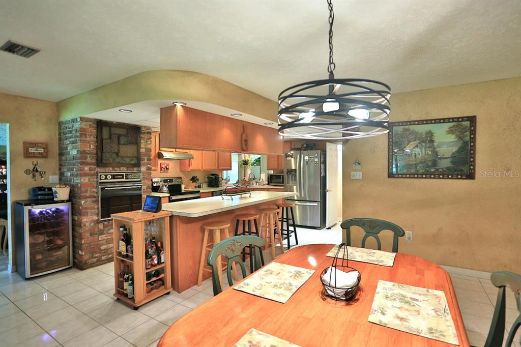 4888 Southwest 7th Avenue Road Ocala, FL 34471 - Photo 17 of 50 a dining room with stainless steel appliances granite countertop a dining table chairs and chandelier