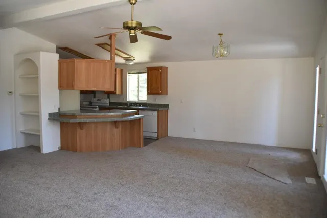 a kitchen with stainless steel appliances granite countertop a sink a stove and a refrigerator