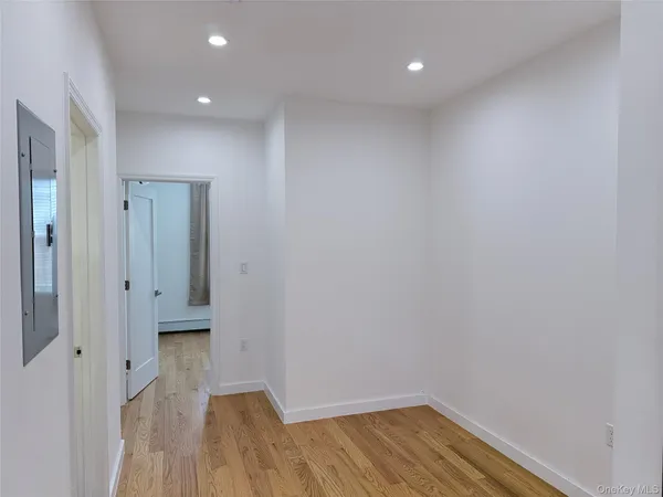 a hallway with stairs and wooden floor