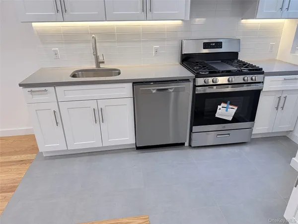 a kitchen with stainless steel appliances granite countertop a sink a stove a microwave and cabinets