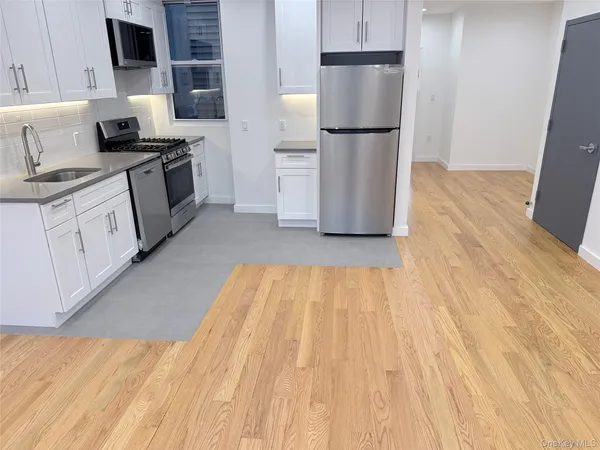 a kitchen with white cabinets and stainless steel appliances