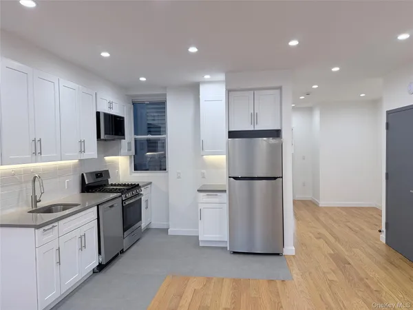 a kitchen with stainless steel appliances granite countertop a refrigerator and a stove top oven