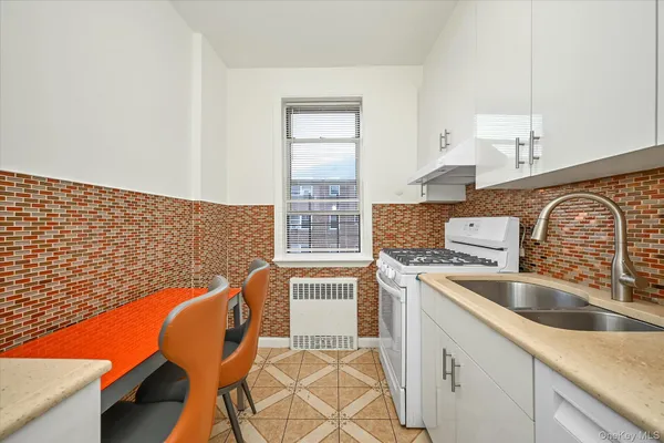 a kitchen with stainless steel appliances granite countertop a sink a stove and white cabinets