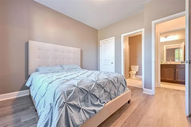 a bedroom with a bed and closet with wooden floor