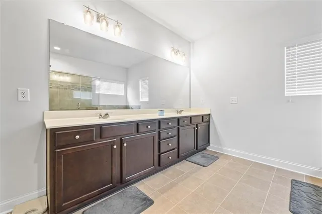 a spacious bathroom with a double vanity sink and mirror